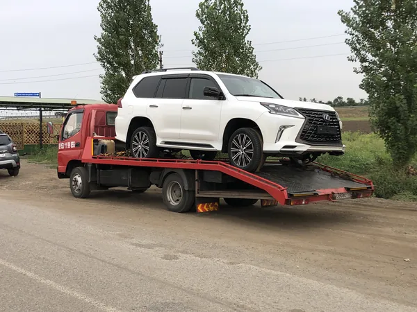 Белый внедорожник Lexus на эвакуаторе